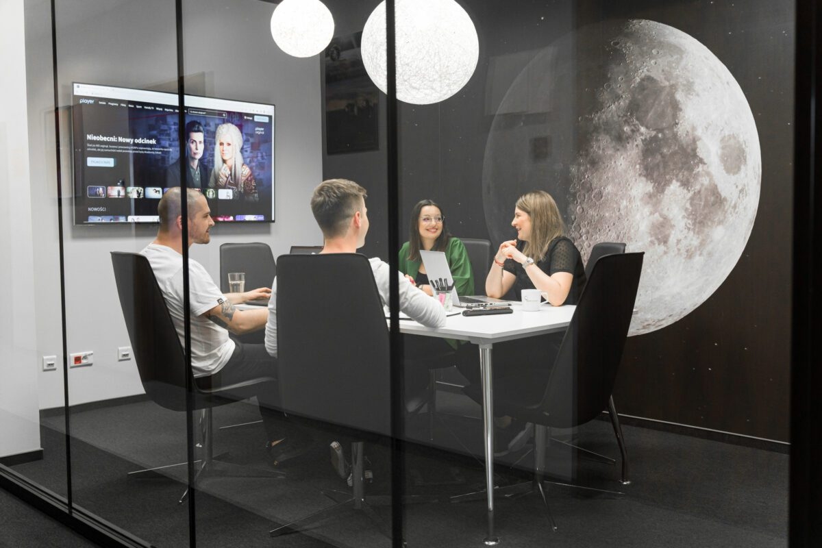 Photo of four people sitting and talking to each other in a conference room.